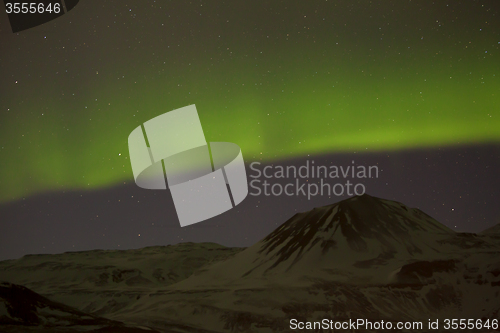 Image of Northern lights with snowy mountains in the foreground