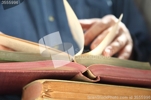 Image of man looks through books   