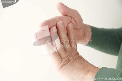 Image of man flexing fingers against hand	