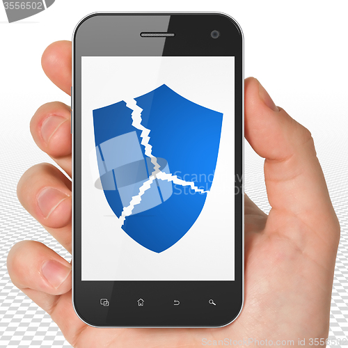 Image of Security concept: Hand Holding Smartphone with Broken Shield on display