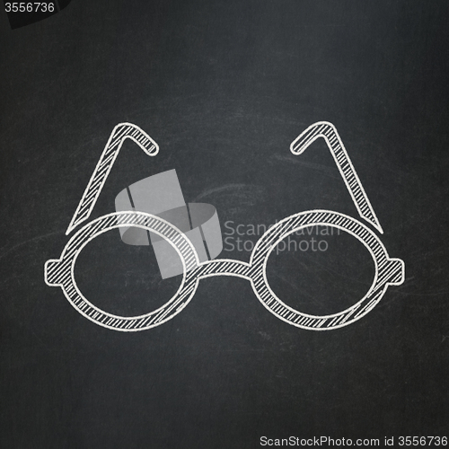 Image of Studying concept: Glasses on chalkboard background