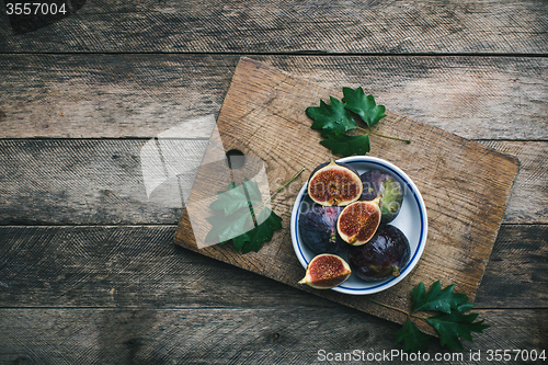 Image of Ripe Figs on cutting board and wooden table