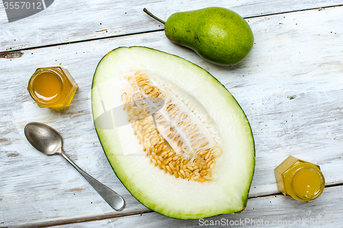 Image of Tasty pear with melon and honey on rustic board