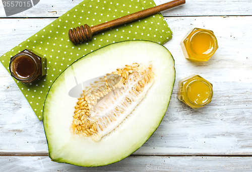 Image of Healthy melon with honey on napkin and rustic board