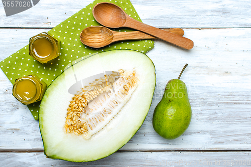 Image of Healthy cut melon pear and honey on white board