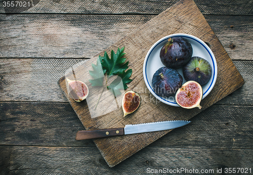 Image of Cut Figs and knife on chopping board in rustic style
