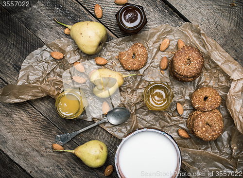 Image of Tasty Pears almonds Cookies and milk on rustic wood