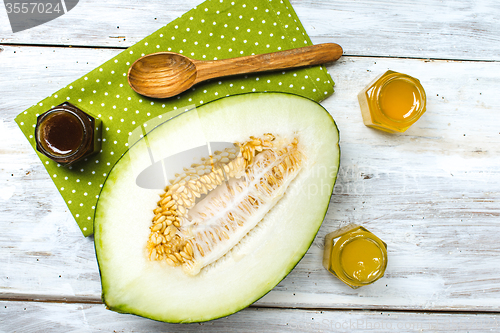 Image of Melon with honey on napkin and rustic board