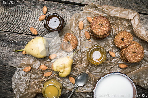 Image of Tasty Pears almonds Cookies and cream on rustic wood