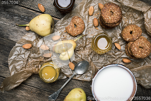 Image of Tasty Pears nuts Cookies and joghurt on rustic wood