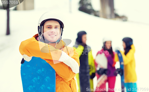 Image of happy friends in helmets with snowboards