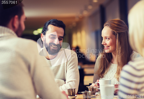 Image of happy friends meeting and drinking tea or coffee