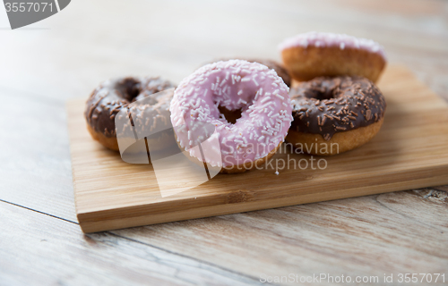 Image of close up of glazed donuts pile on wooden table