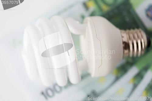 Image of close up of euro money and light bulb on table