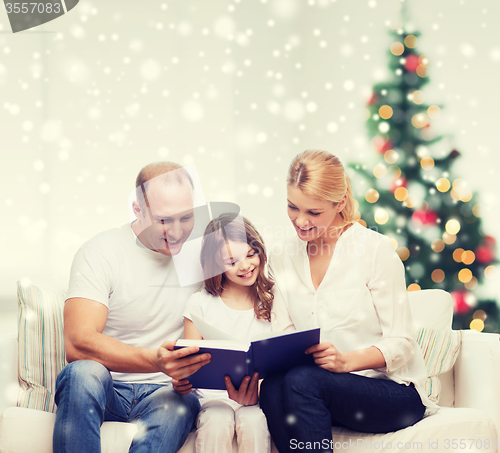 Image of happy family with book at home