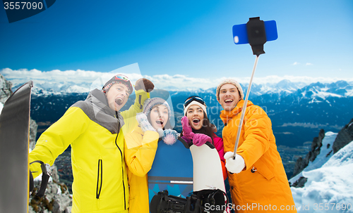 Image of happy friends with snowboards and smartphone