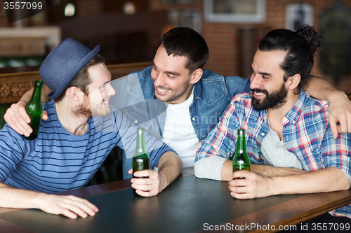 Image of happy male friends drinking beer at bar or pub