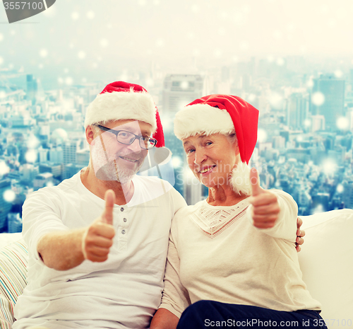 Image of happy senior couple in santa helper hats