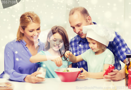 Image of happy family with two kids making salad at home