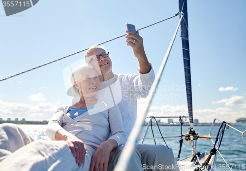 Image of senior couple taking selfie by smartphone on yacht