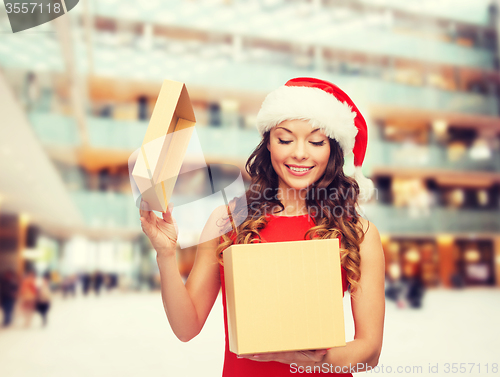 Image of smiling woman in santa helper hat with gift box