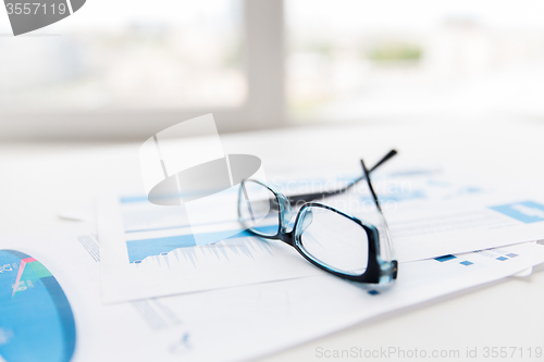 Image of close up of eyeglasses and files on office table