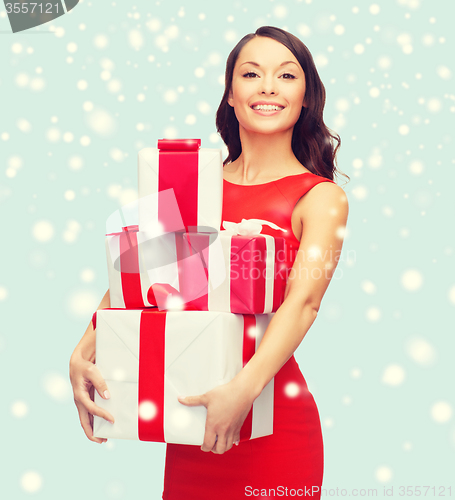 Image of smiling woman in red dress with many gift boxes