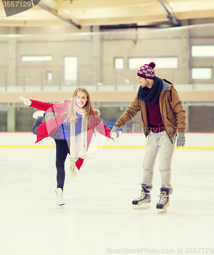 Image of happy couple holding hands on skating rink