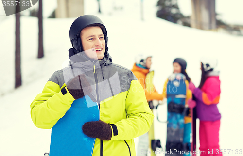 Image of happy friends in helmets with snowboards