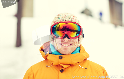 Image of happy young man in ski goggles outdoors