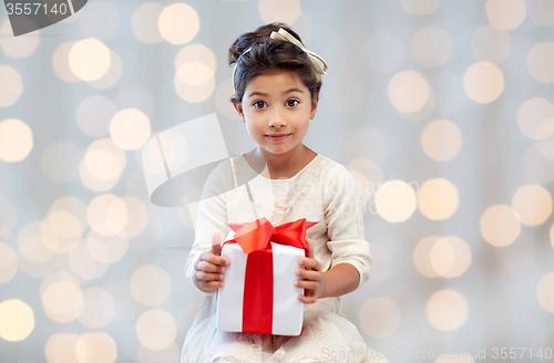 Image of happy little girl with present over lights