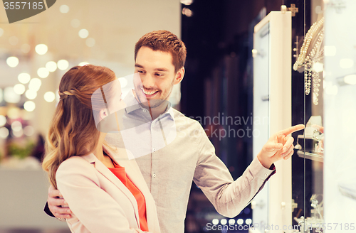 Image of couple looking to shopping window at jewelry store