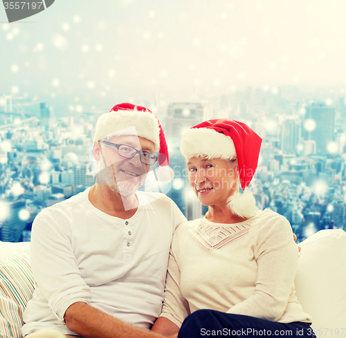 Image of happy senior couple in santa helper hats