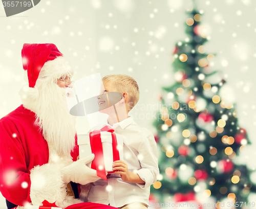 Image of smiling little boy with santa claus and gifts