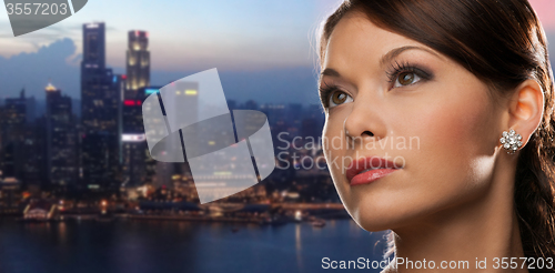 Image of woman with diamond earring over night city