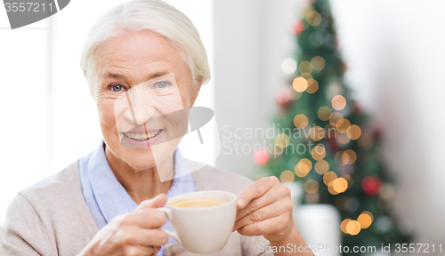 Image of happy senior woman with cup of coffee at home