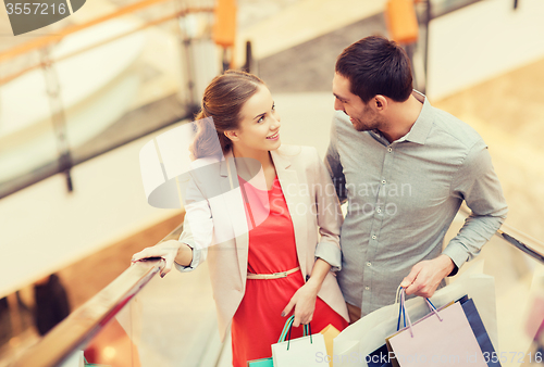 Image of happy young couple with shopping bags in mall