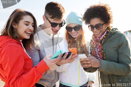 Image of smiling friends with smartphones