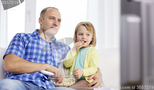 Image of happy family with popcorn watching tv at home