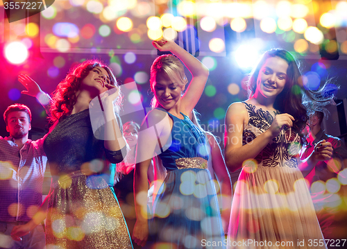 Image of smiling friends dancing in club