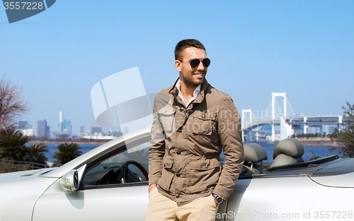 Image of happy man near cabriolet car outdoors