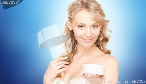 Image of smiling woman cleaning face skin with cotton pad