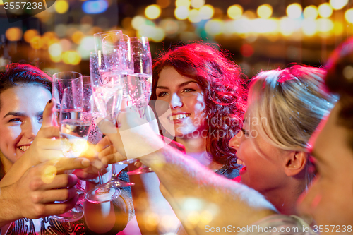 Image of smiling friends with glasses of champagne in club