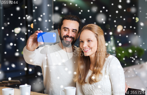 Image of happy couple with smartphone  and coffee at cafe