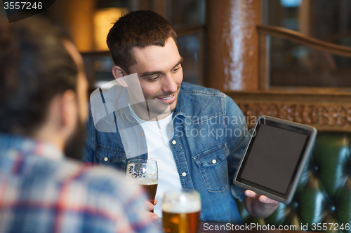 Image of male friends with tablet pc drinking beer at bar