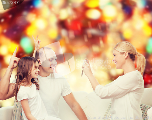 Image of happy family with camera at home