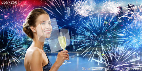 Image of happy woman drinking champagne wine over firework