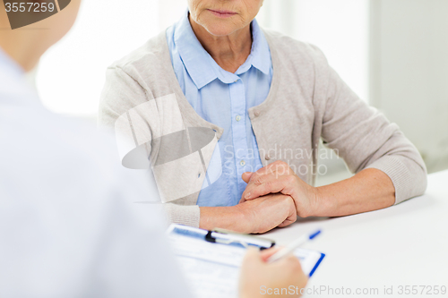 Image of close up of senior woman and doctor with clipboard