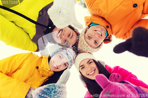 Image of happy friends in winter clothes outdoors