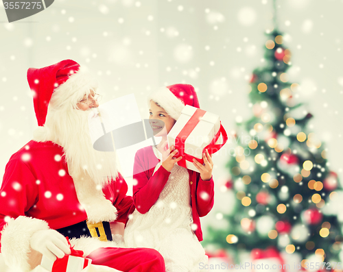 Image of smiling little girl with santa claus and gifts